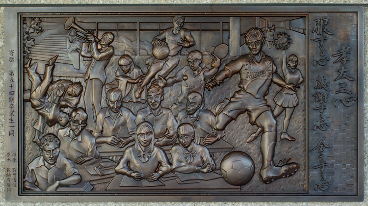 群像と揮毫を立体的にした銅板のレリーフ